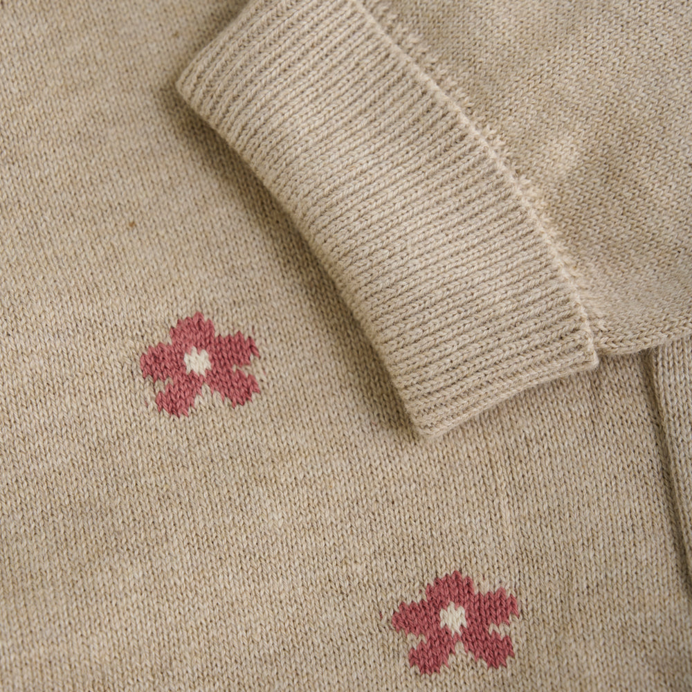 Detailansicht der weichen Strickstruktur und der zarten rosa Blumen der Minymo Babyhose.