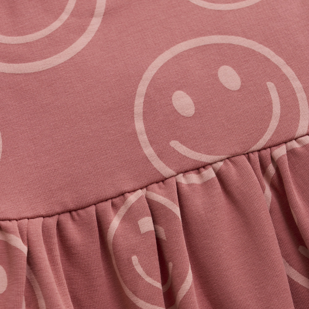 Nahaufnahme des fröhlichen Smiley-Prints auf dem Minymo Langarmkleid.