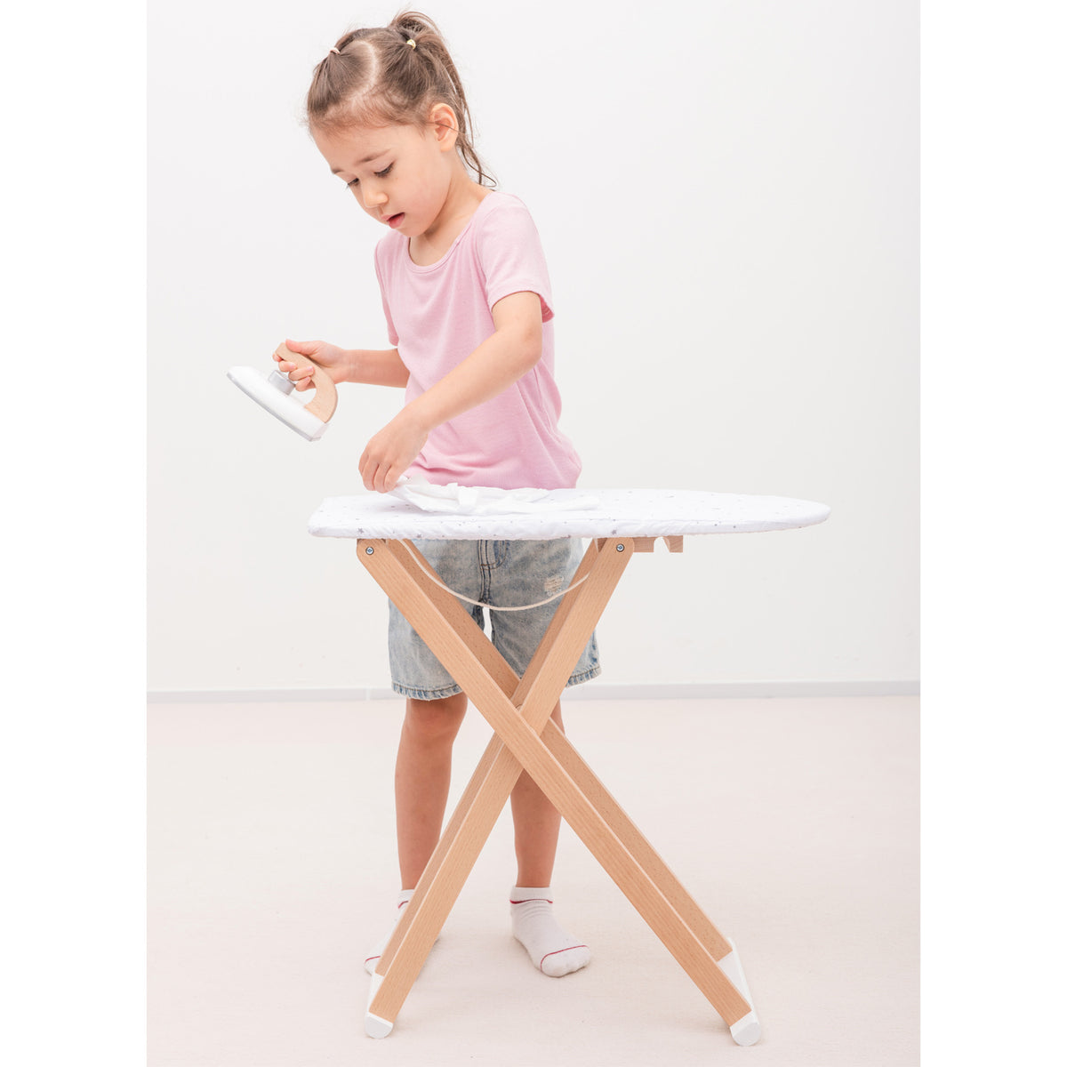 Es ist Waschtag! Mit diesem Bügelbrett und Bügeleisen aus Holz von New Classic Toys können Kinder auf spielerische Weise den Alltag nachahmen und ihre Fantasie entfalten. Das Bügelbrett lädt zum kreativen Spielen ein.