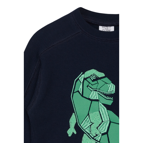 <p>Dieses lange Shirt ist schlicht, aber auf der Brust ziert es ein schöner Dinosaurier. Der bequeme Schnitt ist ideal, um es schnell überzuziehen. Ein Muss für alle Dinosaurier-Fans!</p> <p>&nbsp;</p>