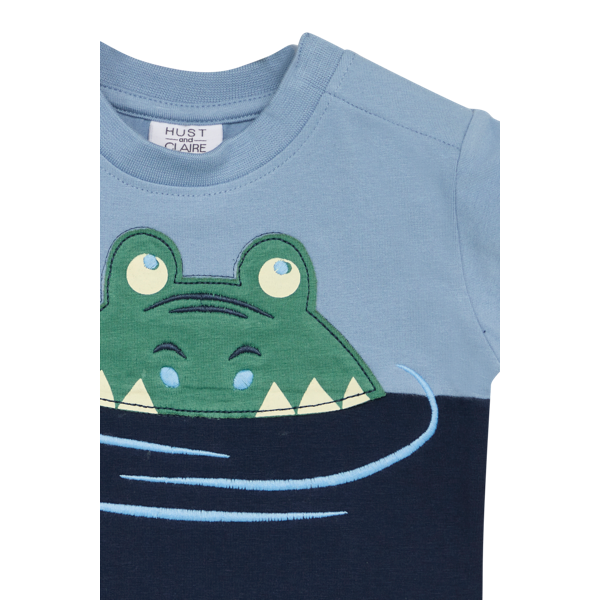 <p><span style="font-size: 0.875rem;">Das T-Shirt ist mit einem Rundhalsausschnitt und in tollen Blautönen erhältlich. Verziert mit einem süßen schwimmenden Krokodil ist es ein echter Blickfang.</span></p> <p>&nbsp;</p>