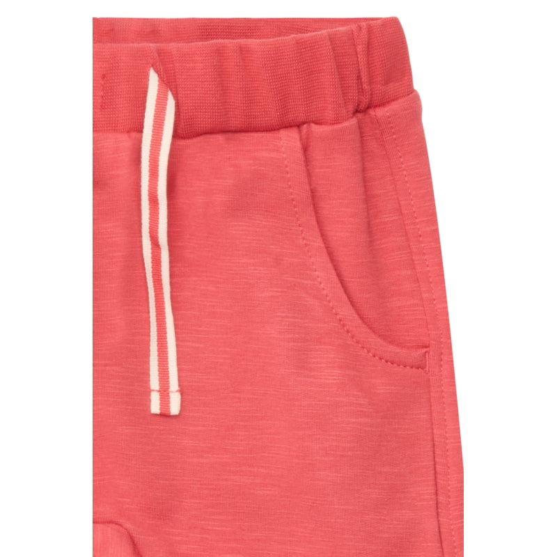 Detailaufnahme der Jogginghose zeigt die kräftige Cranberry-Farbe, die feine Baumwollstruktur und das Schnürband in der elastischen Taille aus nächster Nähe.