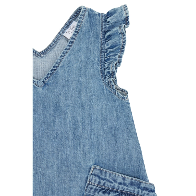 Detailaufnahme des Denim-Kleids zeigt die strukturierte Baumwolle in washed-denim-Farbe, feine Rüschen an der Schulter und den V-Ausschnitt aus nächster Nähe.