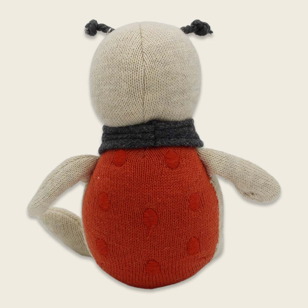 Rückseite. Der Marienkäfer wird von Kindern schnell als Glücksbringer für besonderes herausfordernde Ereignisse oder im Alltag angenommen. Der putzige Käfer trägt einweiches Tuch und auf dem Bauch steht die ermutigende Aufschrift "Glücksbringer.