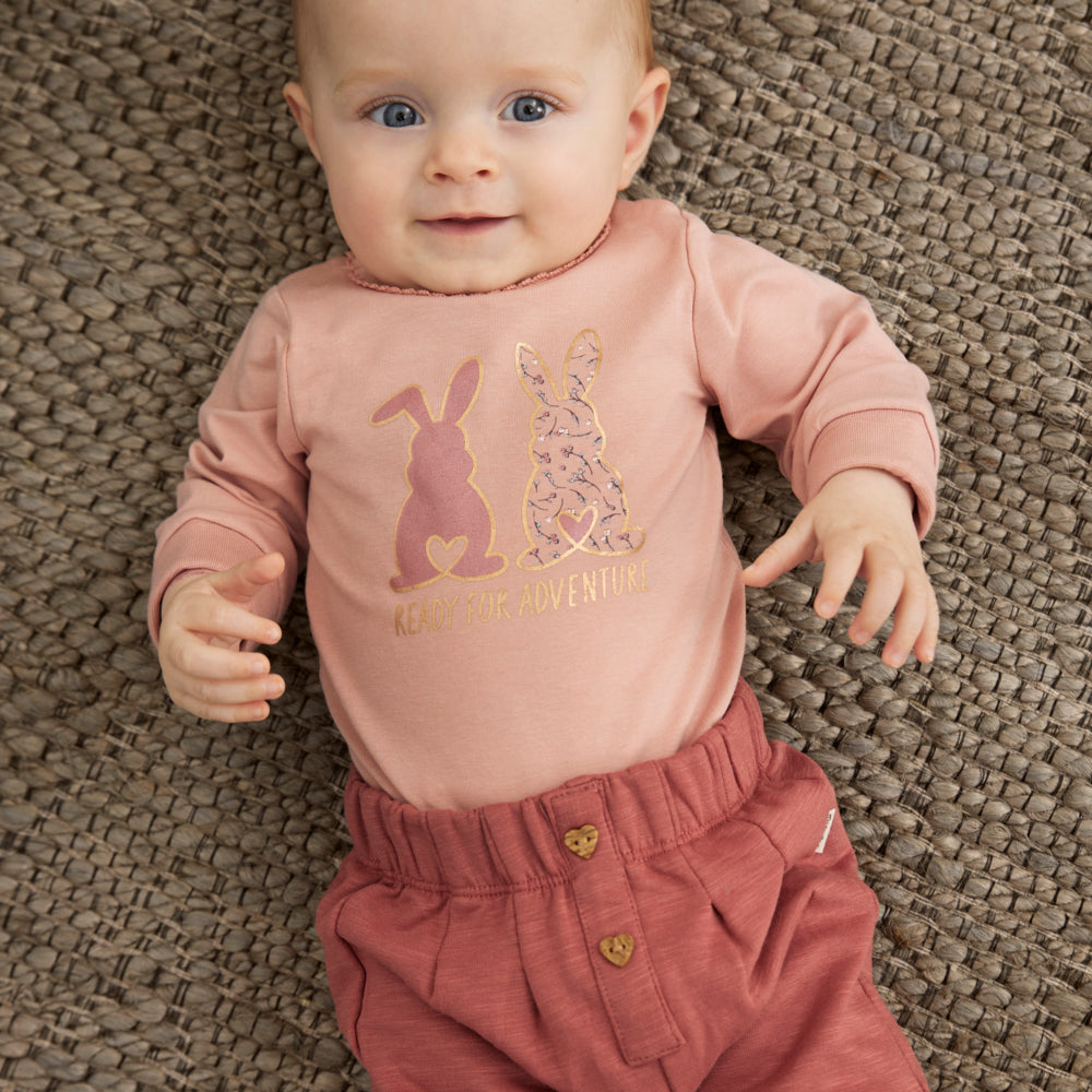 Baby trägt Body mit Sweatpants