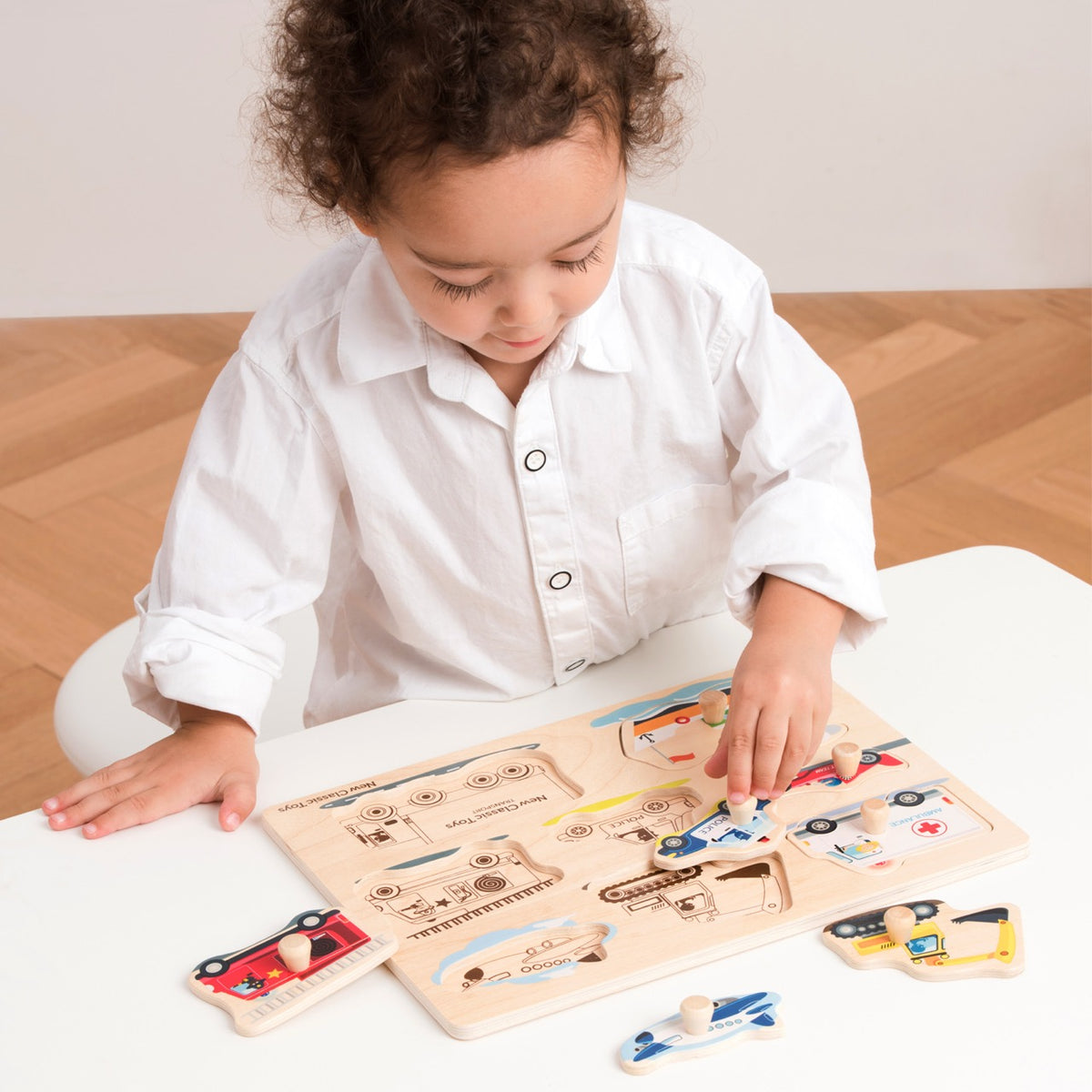 Entdecken Sie die Welt der Transportmittel und Fahrzeuge mit diesem Holzstift-Puzzle von New Classic Toys.&nbsp;Mit einem Krankenwagen, einem Bagger, einem Flugzeug, einem Rennwagen, einem Polizeiauto, einem Feuerwehrauto, einem Boot und einem Lastwagen. Die Bilder unter den Puzzleteilen machen das Lösen des Puzzles einfach und unterhaltsam. 