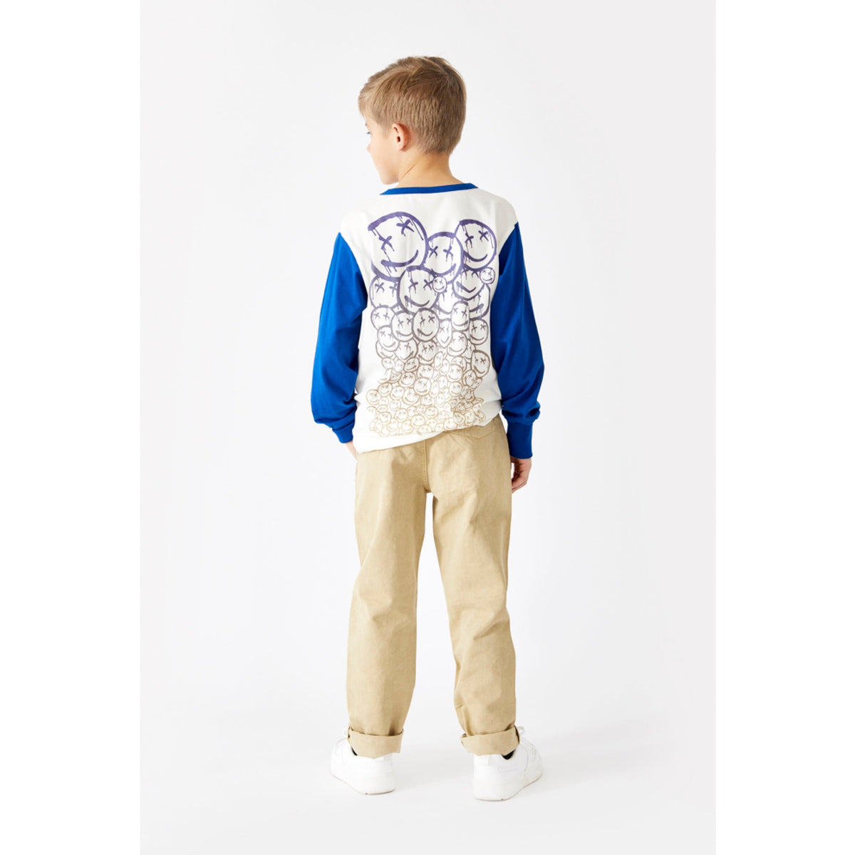 Das Langarmshirt hat einen Aufdruck mit Smileys auf der Rückseite, die Ärmel sind in einem schönen blau gehalten. Der leichte Pullover hat Bündchen an den Ärmeln. Ein cooler Basicartikel für den Winter.