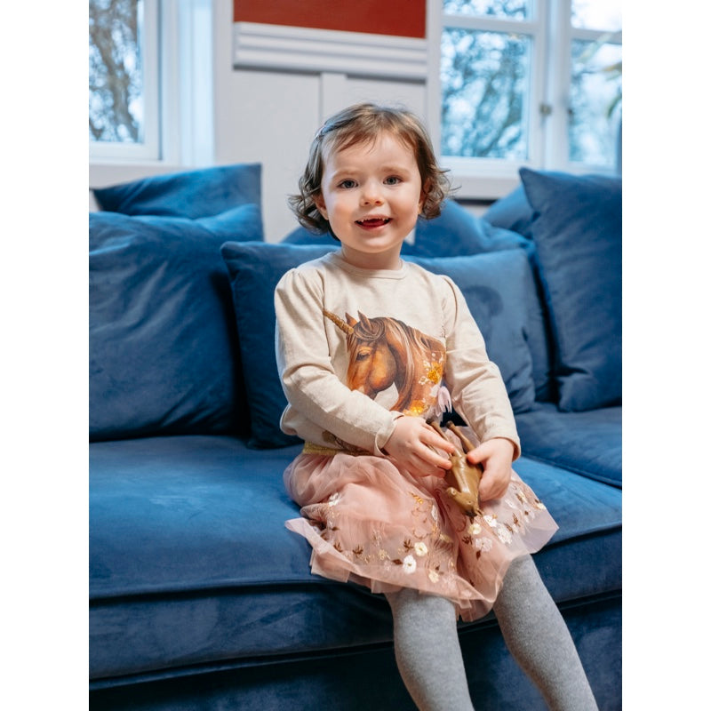 Mädchen sitzt auf Sofa, trägt Langarmshirt Anie von Hust and Claire mit aufgedrucktem Pferd