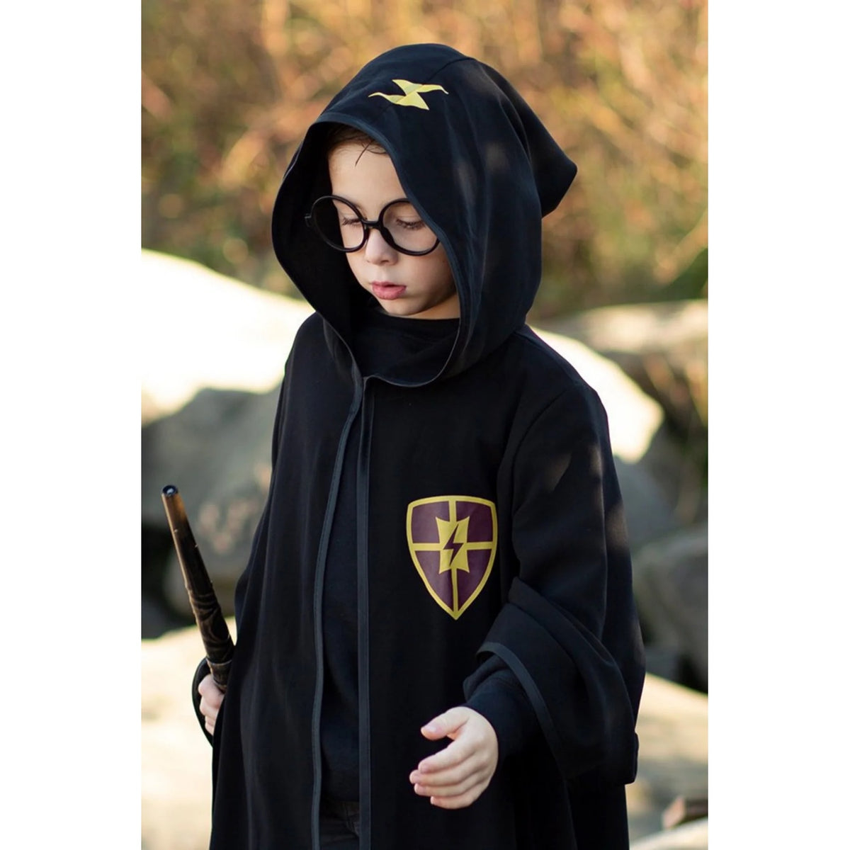 Schwarzer Zauberumhang für Kinder mit passender runder Brille. Das Kostüm besteht aus einem langen, schwarzen Mantel mit Kapuze und wird zusammen mit einer schwarzen Brille präsentiert. Perfekt für Rollenspiele, Fasching, Halloween oder magische Mottopartys