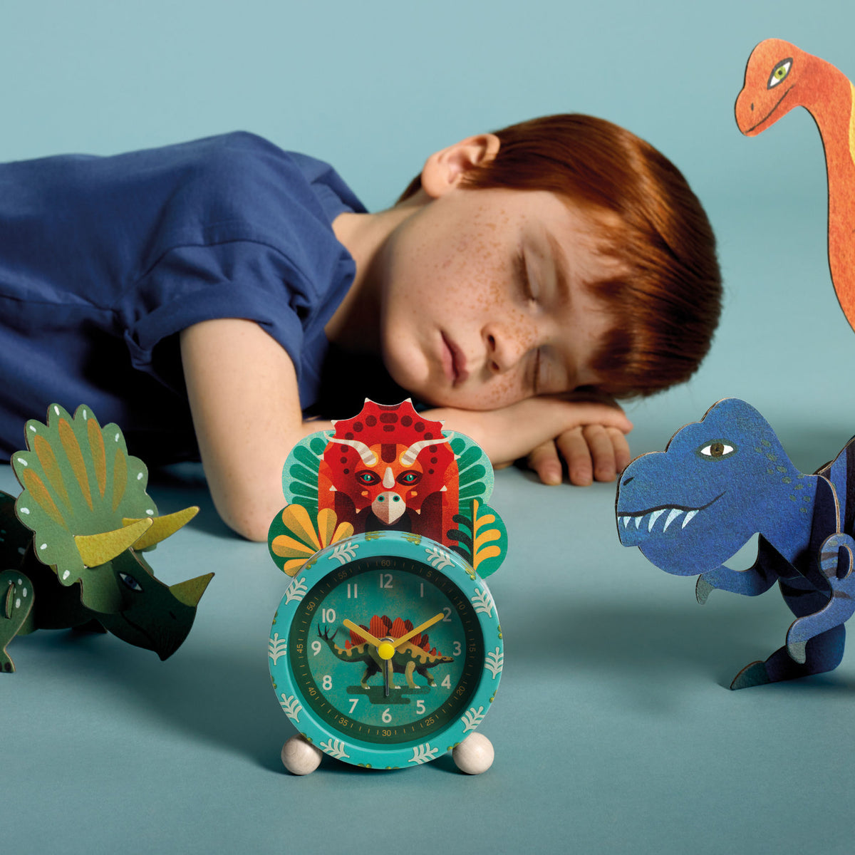 Ein hübsch illustrierter Wecker im Dinosaurier-Thema für ein sanftes Aufwachen und zum Erlernen der Uhrzeit. Die Zeiger zeigen die Stunden, Minuten und Sekunden an und werden von einem geräuschlosen Quarzwerk angetrieben. Dank der Lichttaste kann das Kind die Uhrzeit auch im Dunkeln sehen.