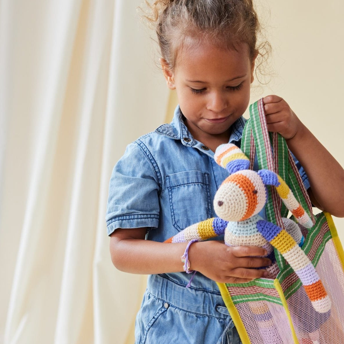 Dieser farbenfroh-gestreifter Langohr-Hase möchte deinem Kind ein treuer Freund werden und mit dir spielen.  Das Kuscheltier wurde mit viel Liebe unter fairen Bedingungen von Hand gefertigt.