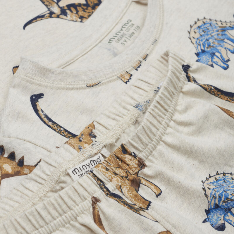 Der Pyjama besteht aus einem Langarmshirt mit Bündchen an den Ärmeln und einer Hose mit einem weichen Bündchen an der Taille und den Beinenden. Er hat ein tolles Dinosaurierprint.