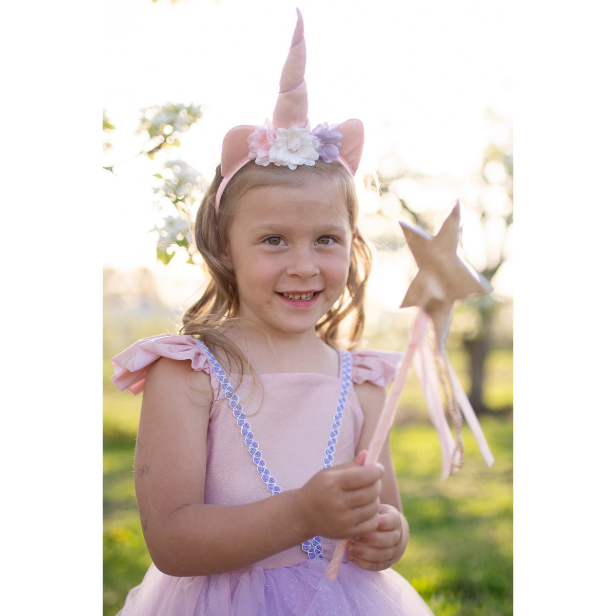 In unserem Set aus schimmerndem Einhornkleid und Stirnband siehst du aus und fühlst dich so magisch wie ein Einhorn. Das Set besteht aus einem zartrosa Kleid mit gerüschten Ärmeln, lilafarbenen Verzierungen und einem voluminösen Tüllrock sowie einem geblümten Einhorn-Stirnband.