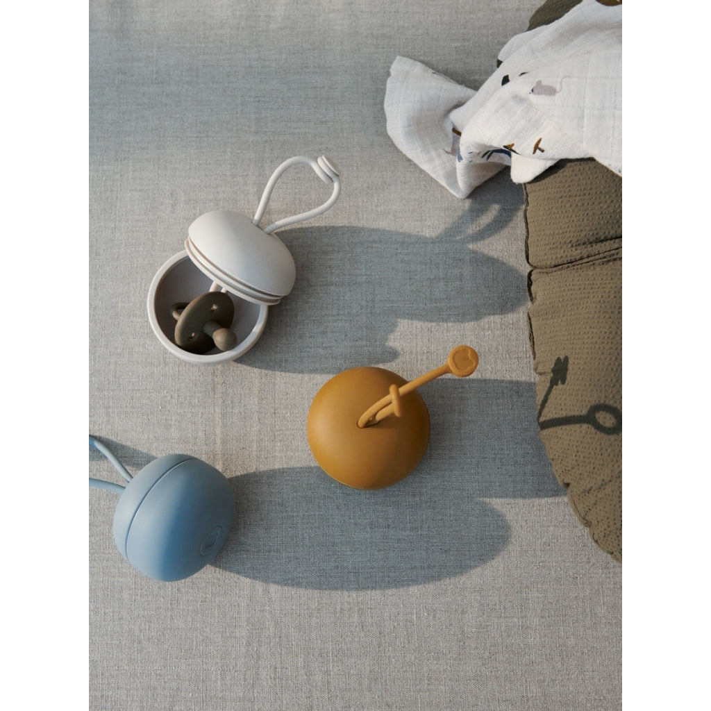 Schnullerbox von Liewood  Die neue Schnullerbox ist der perfekte Ort, um Schnuller unterwegs oder in einer Tasche aufzubewahren. Hergestellt aus - es befestigt an Kinderwagen, Wickeltaschen und mehr.  Die Box kann bis zu drei Schnuller auf einmal aufnehmen. Hergestellt aus